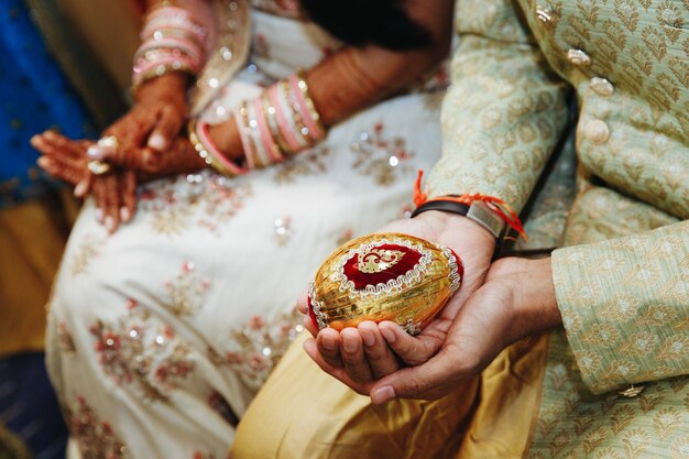 Sosteniendo el objeto sagrado de la boda india en las manos