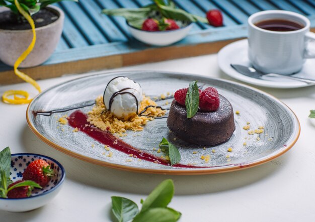 soufflé de chocolate volcán servido con helado de vainilla con jarabe de frambuesa