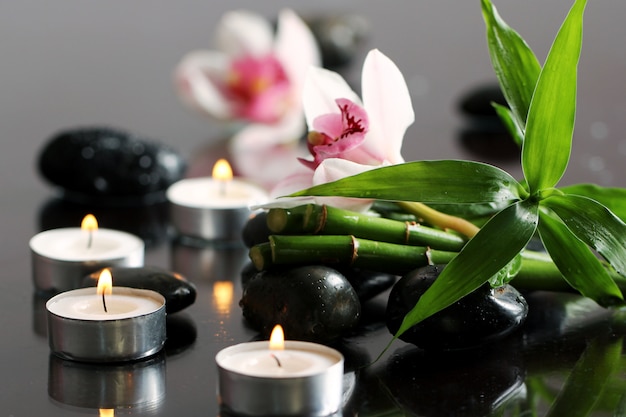 Spa y bienestar, masaje con piedras y flores sobre mantel de madera