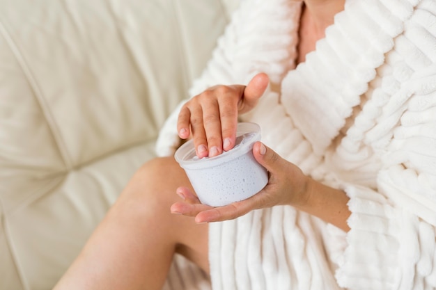 Spa en casa mujer de alta vista aplicando crema