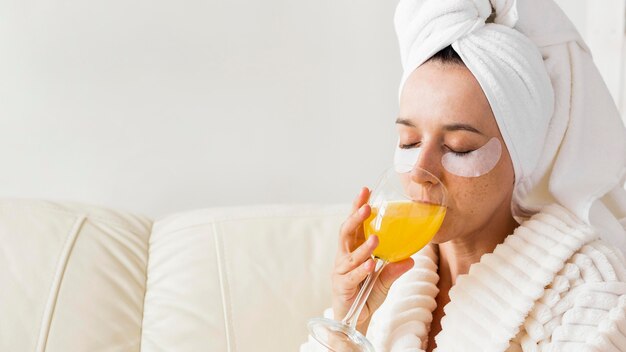 Spa en casa mujer bebiendo jugo saludable de cerca