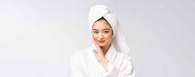 Spa cuidado de la belleza belleza mujer asiática secar el cabello con una toalla en la cabeza después del tratamiento de ducha Hermosa joven multirracial tocando la piel suave