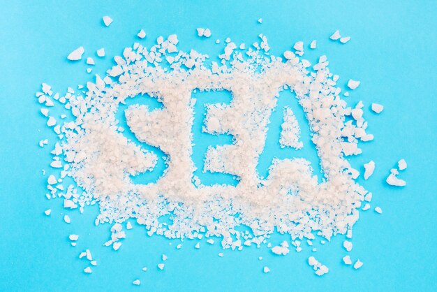 Spa palabra escrita con sal de baño sobre fondo azul.