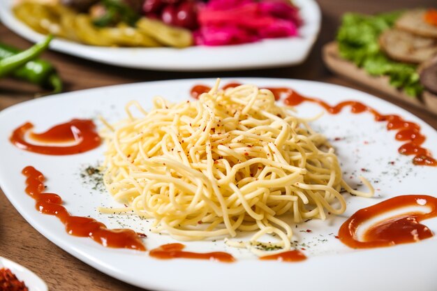 Spaghetti con vista cercana de pimiento rojo y salsa de tomate