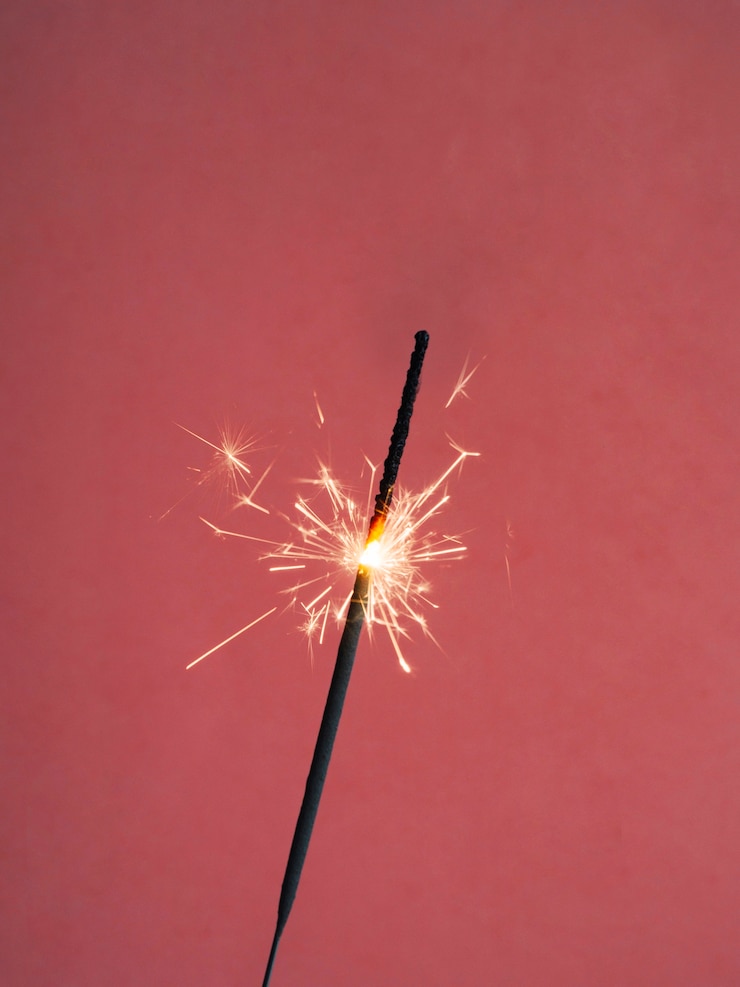 Foto gratuito sparkler lighting on red