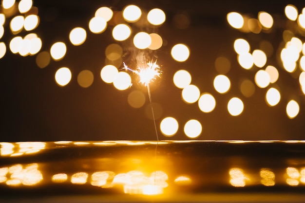 Sparkler y luces sobre superficie reflectante