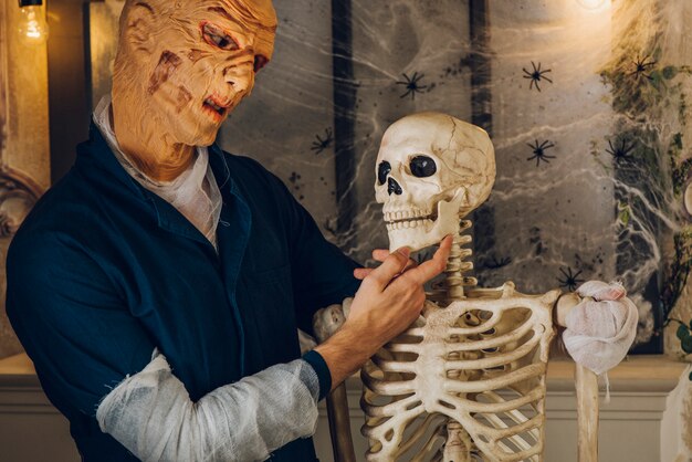 Spooky hombre posando con el esqueleto
