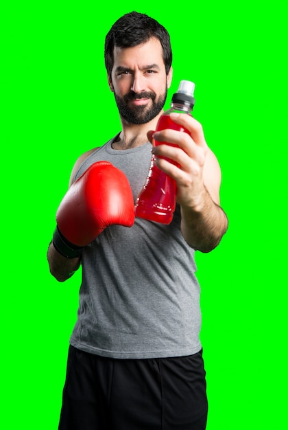 Sportman con guantes de boxeo de agua potable soda