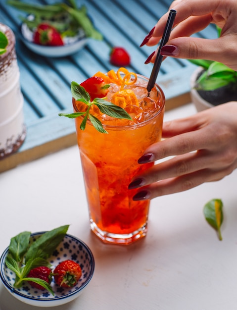 starberry y jugo de naranja con partículas de hielo, fresa y naranja