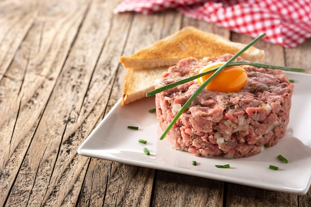 Steak tartar de ternera sobre mesa de madera