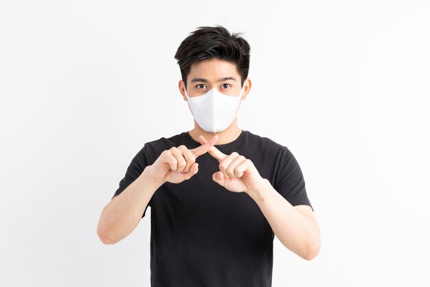 Stop Civid-19, hombre asiático con máscara facial muestra gesto de detener las manos para detener el brote del virus corona