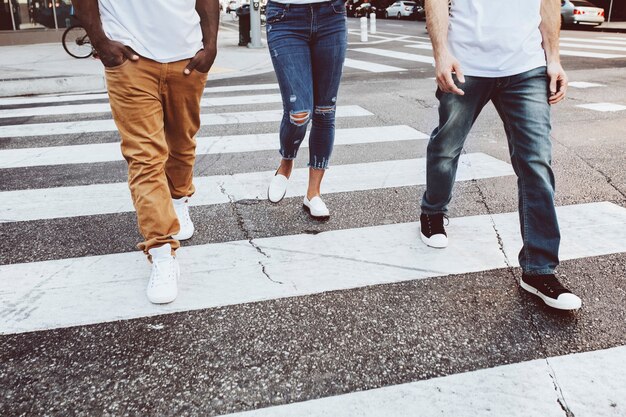 Streetwear ropa jeans hombres y mujeres cruzando la calle en la ciudad