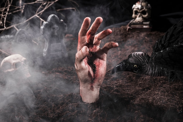 Sucio zombie mano y miedo pájaro en el cementerio de Halloween