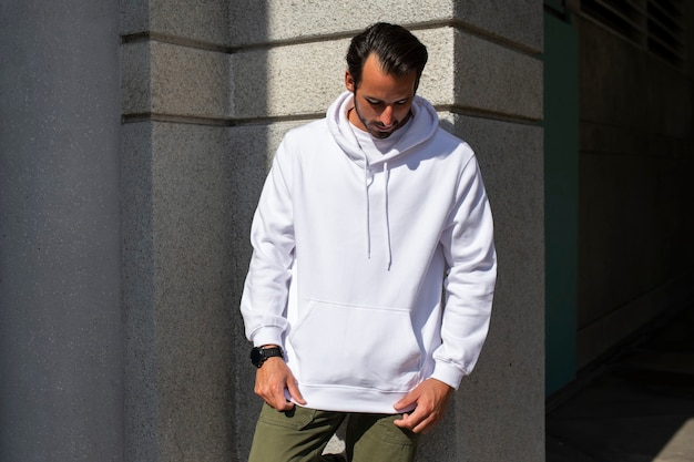 Sudadera con capucha blanca en hombre con pantalón verde en la ciudad