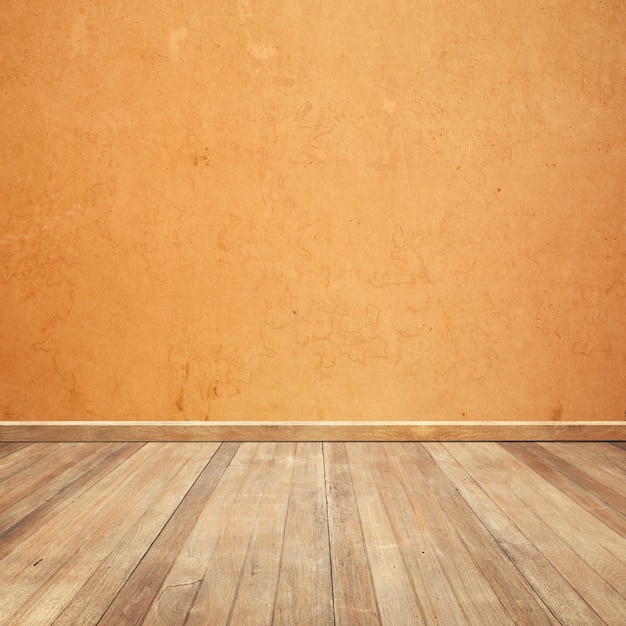 Suelo de madera con una pared naranja de fondo