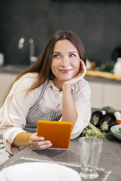 En sueños. Mujer joven sentada en la cocina y mirando pensativo