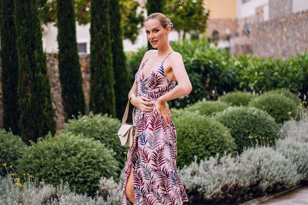 Summet retrato de moda de mujer joven con estilo posando en vacaciones de lujo con vestido de verano elegante