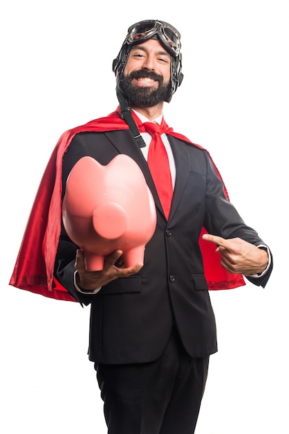 Super héroe hombre de negocios la celebración de un piggybank