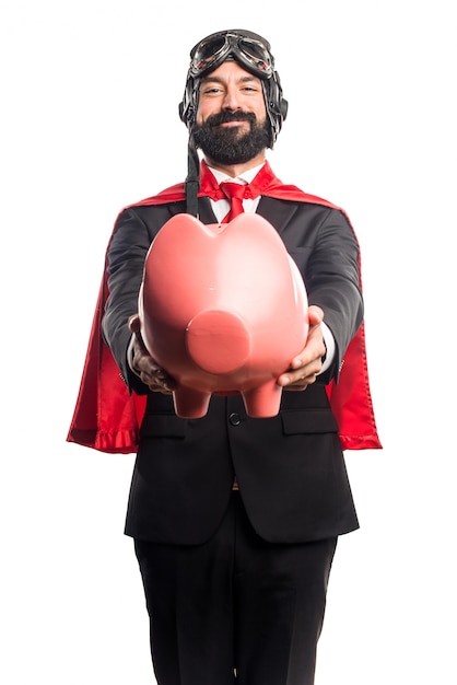 Super héroe hombre de negocios la celebración de un piggybank