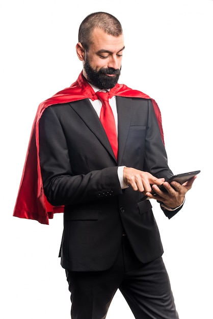 Foto gratuita super héroe hombre de negocios la celebración de una tableta
