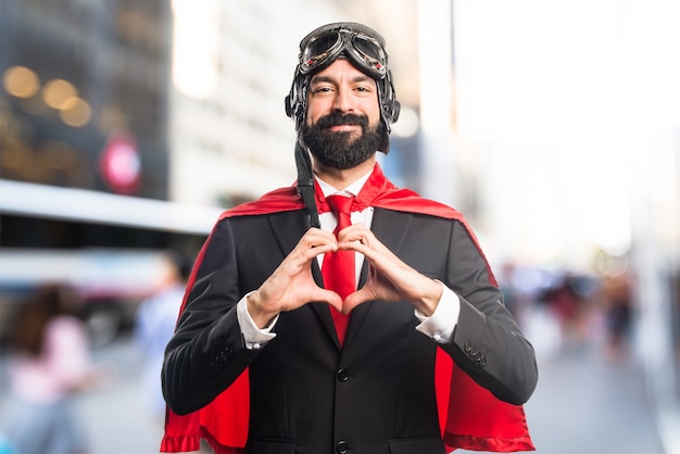 Super héroe hombre de negocios haciendo un corazón con sus manos