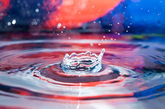 Superficie de agua con salpicaduras y fondo colorido