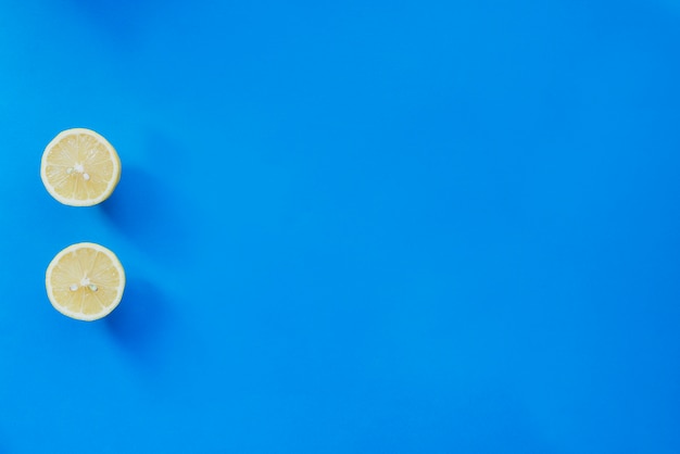 Foto gratuita superficie azul con limón cortado por la mitad y espacio en blanco