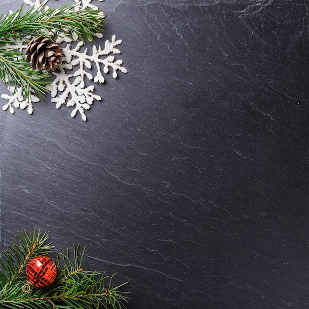 Superficie gris con ramas de pino ornamental de Navidad y un copo de nieve con espacio de copia