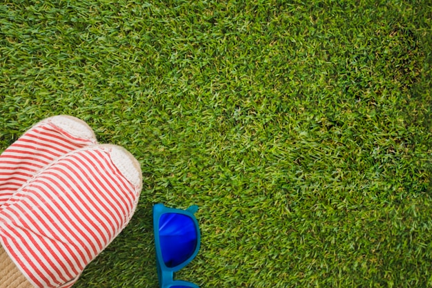 Superficie de hierba con gafas de sol y zapatos de verano