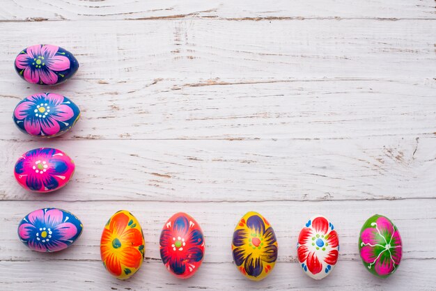 Superficie de madera blanca con huevos de colores para pascua