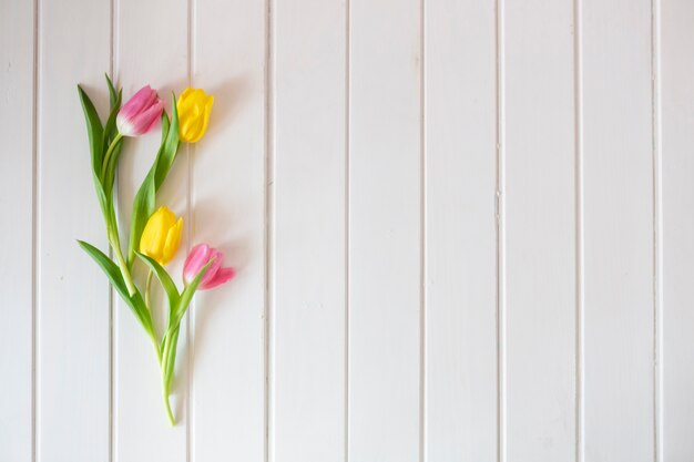 Superficie de madera blanca con tulipanes bonitos