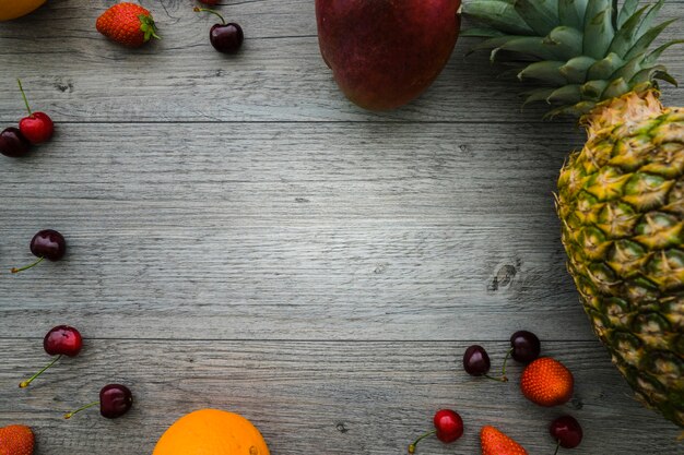 Superficie de madera con espacio en blanco y frutas veraniegas