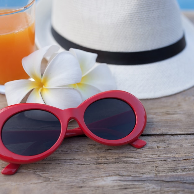 Superficie de madera con gafas de sol y sombrero