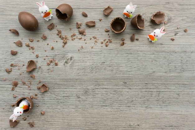 Superficie de madera con huevos de pascua y conejos