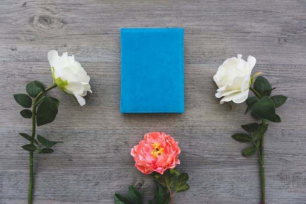 Foto gratuita superficie de madera con libro y flores bonitas