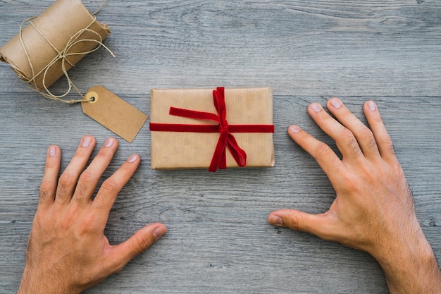 Superficie de madera con manos y regalo para el día del padre