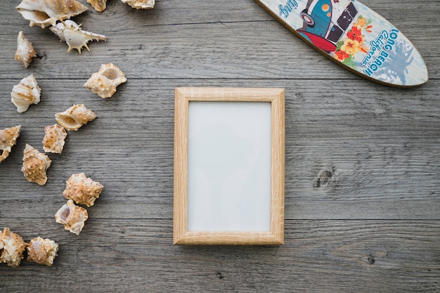 Foto gratuita superficie de madera con tabla de surf, marco y conchas marina