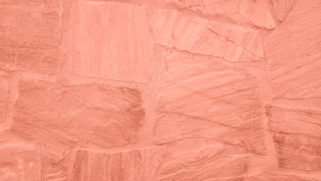 Superficie del muro de piedra con tinte rosado