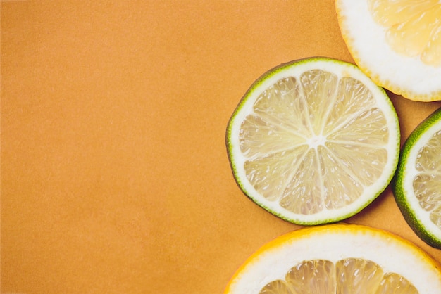 Superficie naranja con rodajas de lima y limón