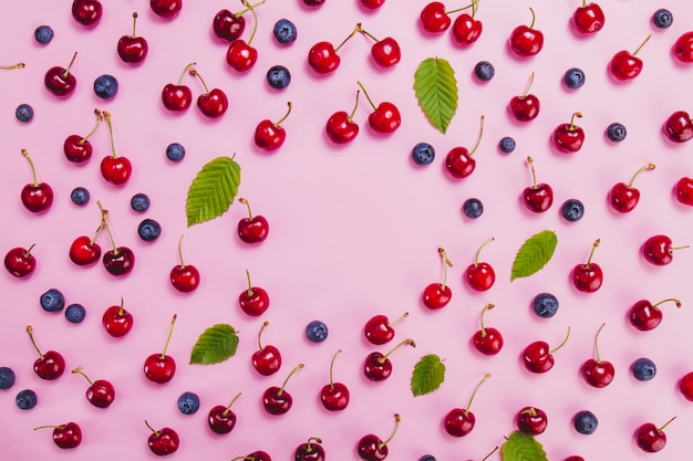 Superficie rosa con arándanos y cerezas sabrosas