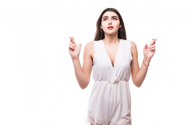 Suplicando hermosa joven modelo en vestido blanco moderno sobre blanco