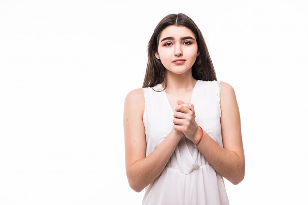 Suplicando hermosa joven modelo en vestido blanco moderno sobre blanco