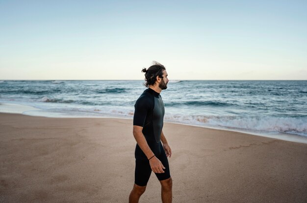 Surfista caminando junto al mar