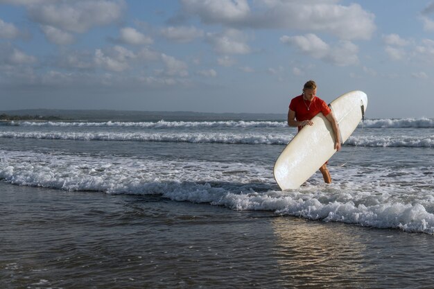 Surfista caminando por la playa. bali