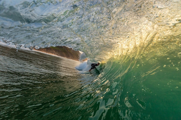 Foto gratuita surfista masculino haciendo trucos apoderándose de las fuertes olas del océano en algarve, portugal