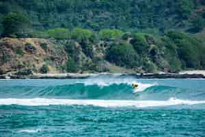 Foto gratuita surfista en una ola azul.
