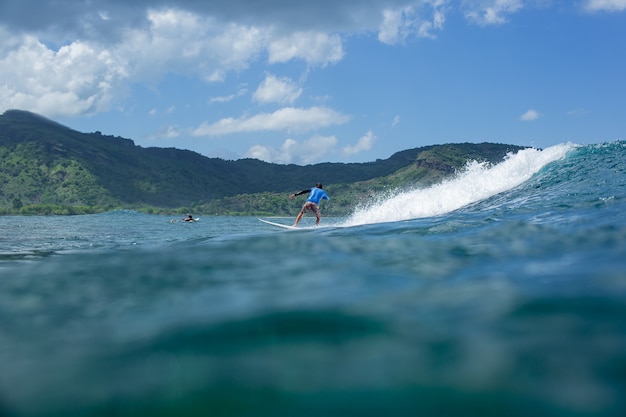 Surfista en una ola azul.