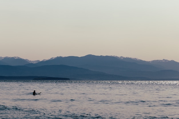 Un surfista con su tabla de surf en el agua.