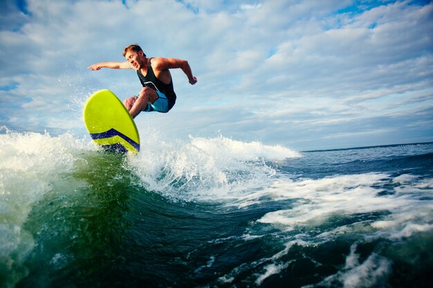 Surfista valiente montando una ola