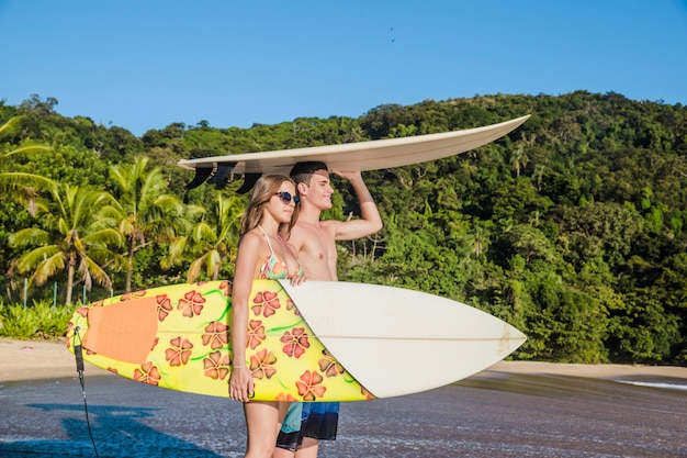 Foto gratuita surfistas posando en la playa